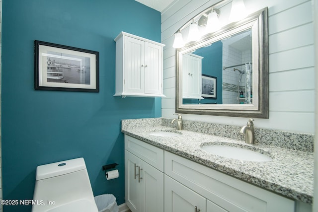 bathroom with double vanity, toilet, a shower, and a sink