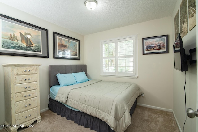 carpeted bedroom with a textured ceiling and baseboards