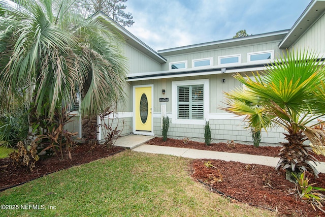 entrance to property with a lawn