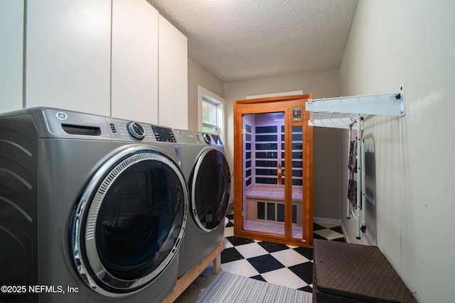 clothes washing area featuring tile patterned floors, independent washer and dryer, a textured ceiling, and cabinet space