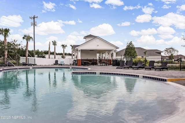 pool with fence and a patio