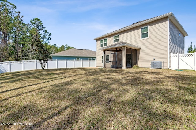 back of house with central air condition unit, a sunroom, a fenced backyard, and a yard