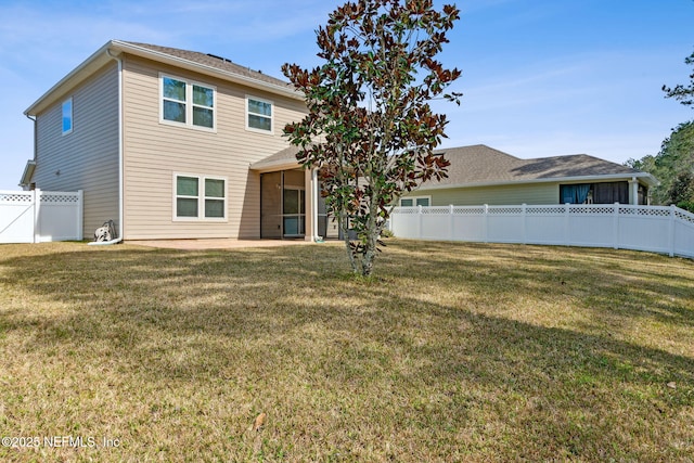 back of property with a yard, a patio area, and a fenced backyard