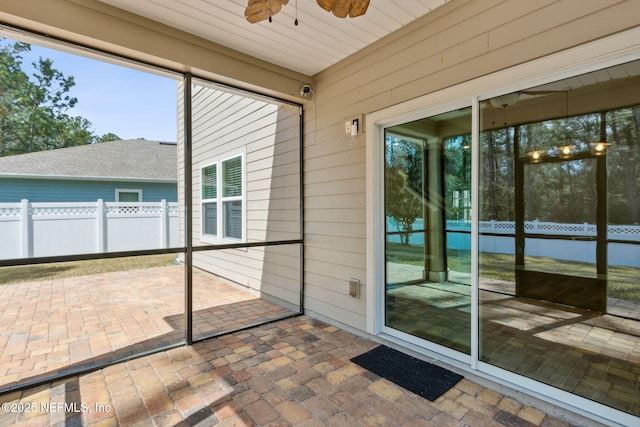 unfurnished sunroom featuring a ceiling fan