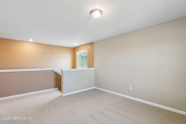 empty room featuring baseboards, recessed lighting, and light colored carpet