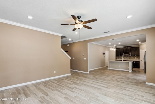 unfurnished living room with ceiling fan with notable chandelier, baseboards, visible vents, and light wood-style floors