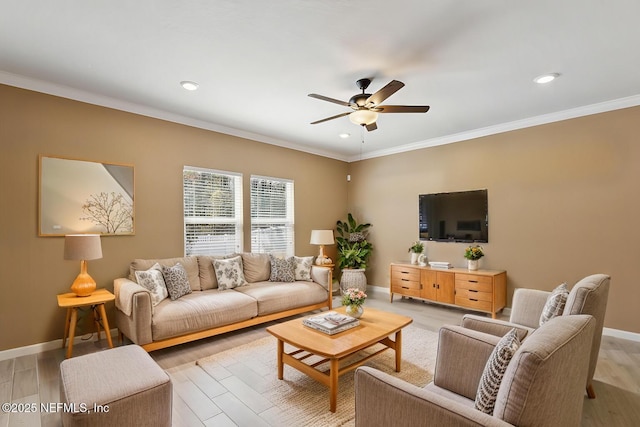 living area featuring light wood-style floors, ceiling fan, ornamental molding, and baseboards