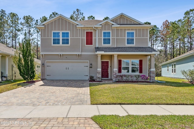 craftsman-style house featuring a garage, decorative driveway, board and batten siding, and a front lawn