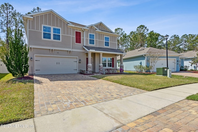 craftsman-style house featuring decorative driveway, board and batten siding, and a front yard