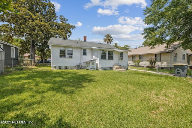 back of house with central AC and a yard