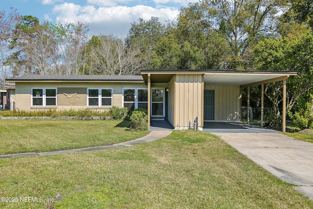 view of front of property featuring a carport, a front yard, concrete driveway, and board and batten siding