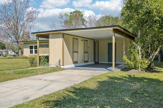 view of front of house featuring driveway, an attached carport, and a front yard