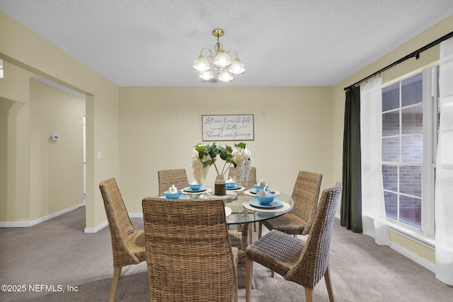 dining room featuring baseboards, carpet floors, a textured ceiling, and an inviting chandelier