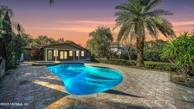 view of swimming pool featuring a pool with connected hot tub and a patio