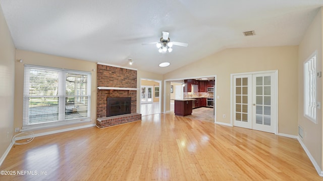 unfurnished living room featuring light wood-type flooring, french doors, visible vents, and a fireplace