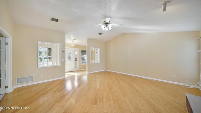 spare room featuring a textured ceiling, a ceiling fan, visible vents, and light wood-style floors