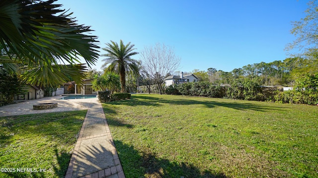 view of yard with an outdoor pool, a fire pit, and a patio