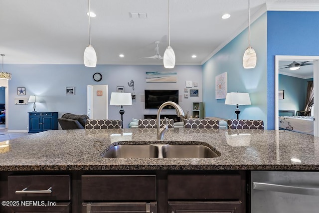 kitchen featuring decorative light fixtures, sink, crown molding, and stone counters