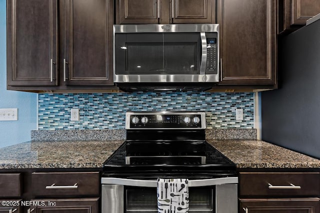 kitchen featuring dark stone countertops, appliances with stainless steel finishes, dark brown cabinetry, and decorative backsplash