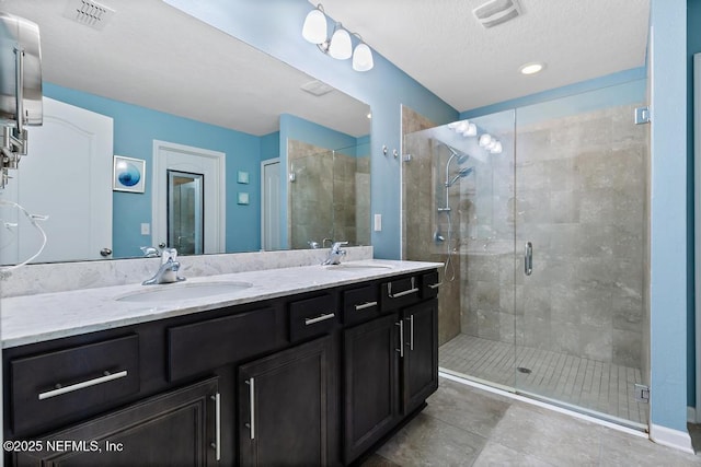 bathroom featuring tile patterned flooring, vanity, and walk in shower