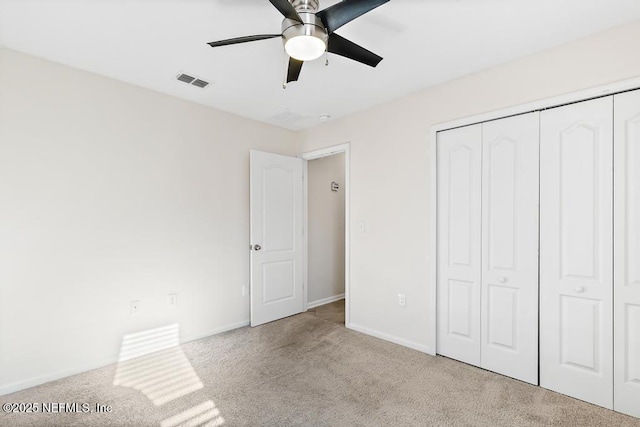 unfurnished bedroom featuring a closet, ceiling fan, and light colored carpet