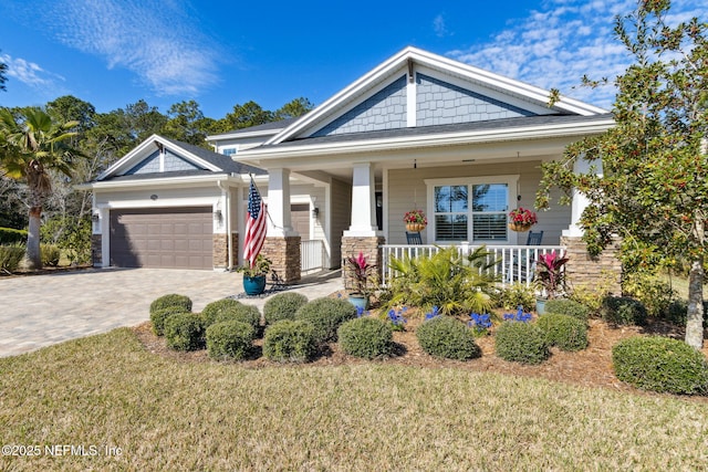 craftsman inspired home featuring a garage, a front lawn, and a porch