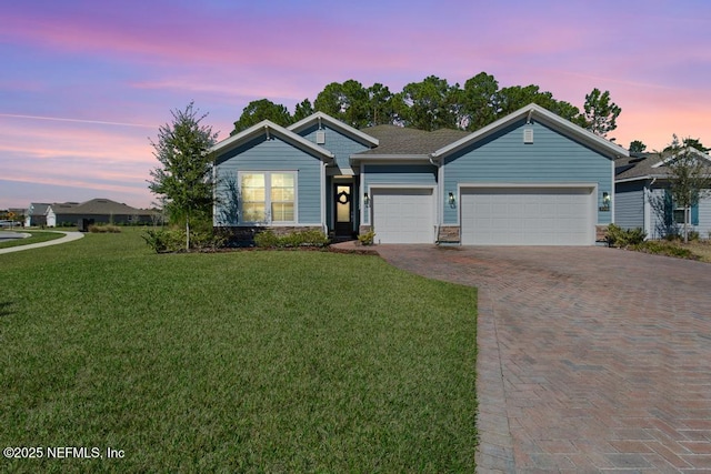 view of front facade with a yard and a garage