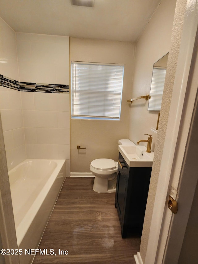 full bath featuring toilet, baseboards, wood finished floors, and vanity