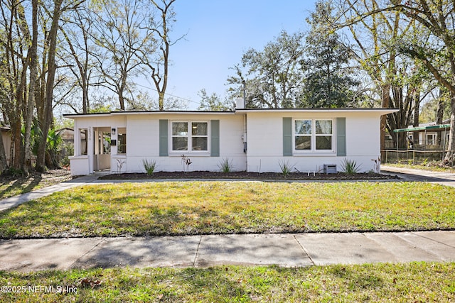 view of front of property with a front lawn and concrete block siding