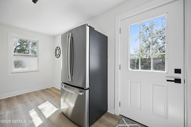 kitchen with baseboards, wood finished floors, and freestanding refrigerator