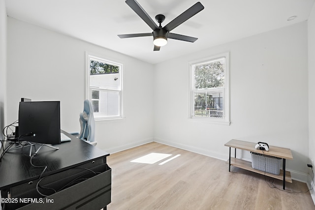 home office featuring baseboards, ceiling fan, and light wood finished floors