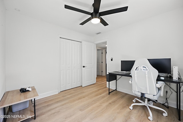 office space with a ceiling fan, wood finished floors, visible vents, and baseboards