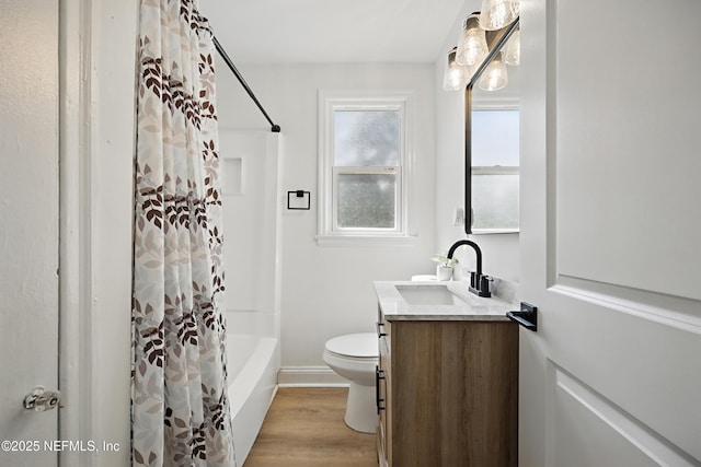 full bathroom with baseboards, toilet, wood finished floors, shower / bath combo with shower curtain, and vanity