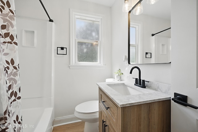 bathroom with baseboards, vanity, toilet, and wood finished floors