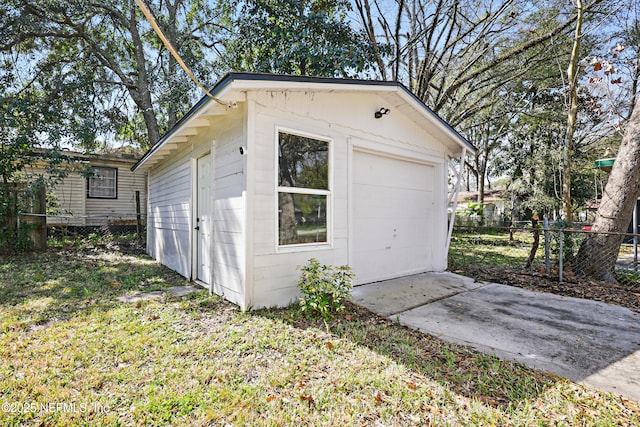 detached garage with fence and driveway