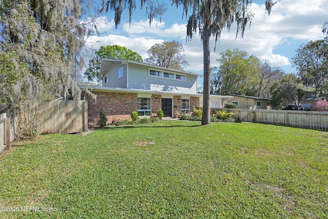 back of house featuring a garage, a lawn, a fenced backyard, and brick siding