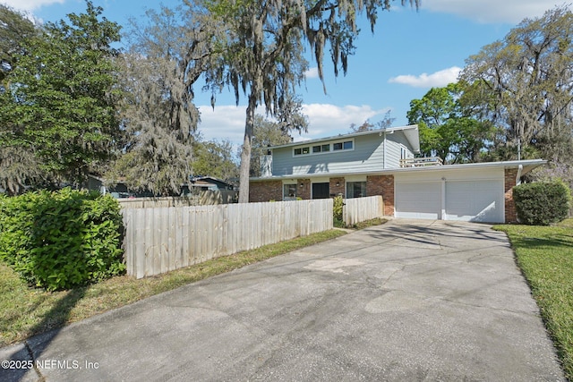 view of property exterior with a garage, brick siding, concrete driveway, and fence