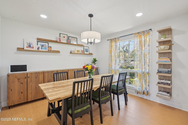 dining space featuring light wood finished floors and recessed lighting