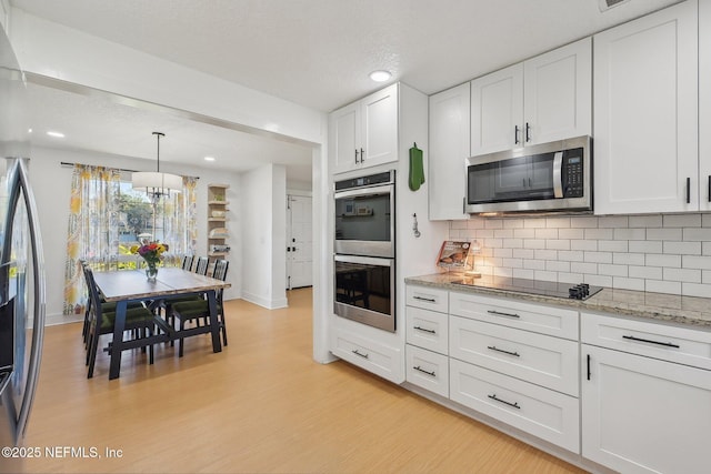 kitchen featuring light wood-style floors, a notable chandelier, appliances with stainless steel finishes, and white cabinets