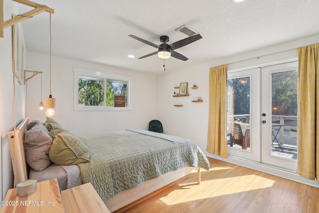 bedroom featuring wood finished floors, visible vents, access to exterior, french doors, and a textured ceiling