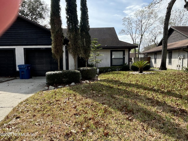 ranch-style house featuring a garage and a front lawn