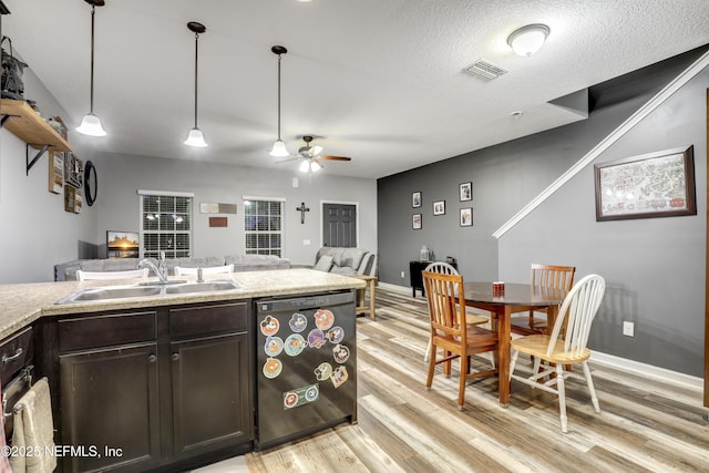 kitchen with dishwasher, light countertops, a sink, and pendant lighting