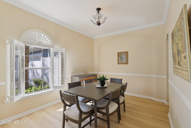 dining space with light wood-type flooring and ornamental molding