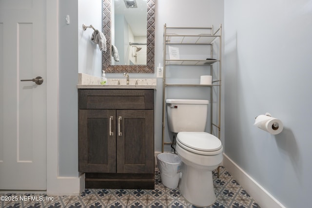 bathroom with toilet, baseboards, and vanity