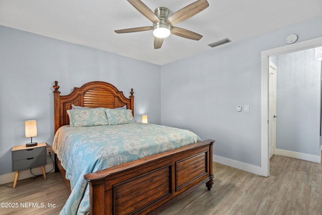 bedroom featuring light wood-style floors, visible vents, ceiling fan, and baseboards