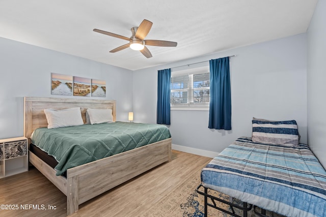 bedroom with wood finished floors, a ceiling fan, and baseboards