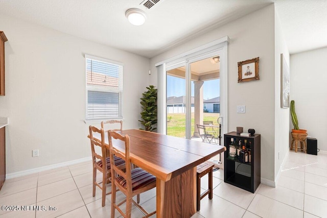 dining area with plenty of natural light, baseboards, visible vents, and light tile patterned floors