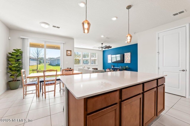 kitchen with decorative light fixtures, visible vents, and light tile patterned flooring