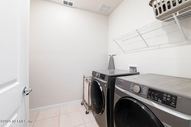 laundry room with light tile patterned floors, visible vents, independent washer and dryer, and laundry area