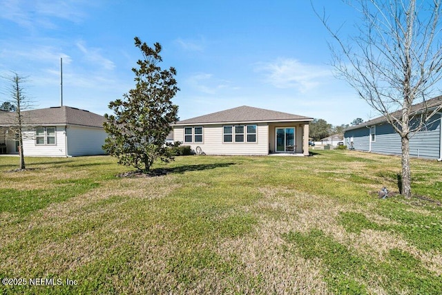 rear view of property with a yard